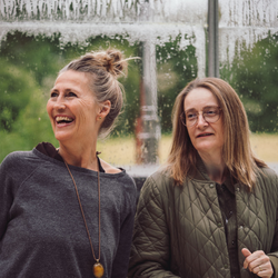 To personer i nærværende dialog i lyse, grønne omgivelser – stemningsbillede der viser ro, fordybelse og fællesskab på Tobias‑Skolens psykoterapeutuddannelse, kurser og efteruddannelser.