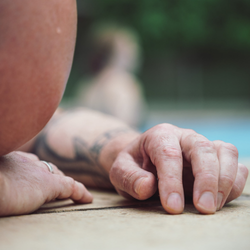 To personer sidder i græsset i rolige, grønne omgivelser og deltager i en nærværende samtale – illustrerer tryghed, relationel kontakt og personlig udvikling på Tobias‑Skolens psykoterapeutuddannelse, kurser og efteruddannelser.