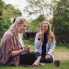 o personer i nærværende samtale i grønne omgivelser – stemningsbillede der viser fordybelse, tryghed og relationel kontakt som en del af Tobias‑Skolens psykoterapeutuddannelse, kurser og efteruddannelser.