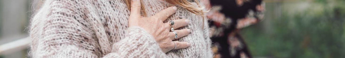 Person med hånden placeret på brystet i en rolig, mindful kropsøvelse – stemningsbillede der illustrerer selvkontakt, nærvær og den terapeutiske tilgang på Tobias‑Skolens psykoterapeutuddannelse, kurser og efteruddannelser.